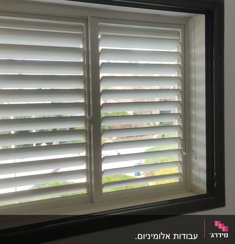 חלון עם תריסי אלומיניום לבנים